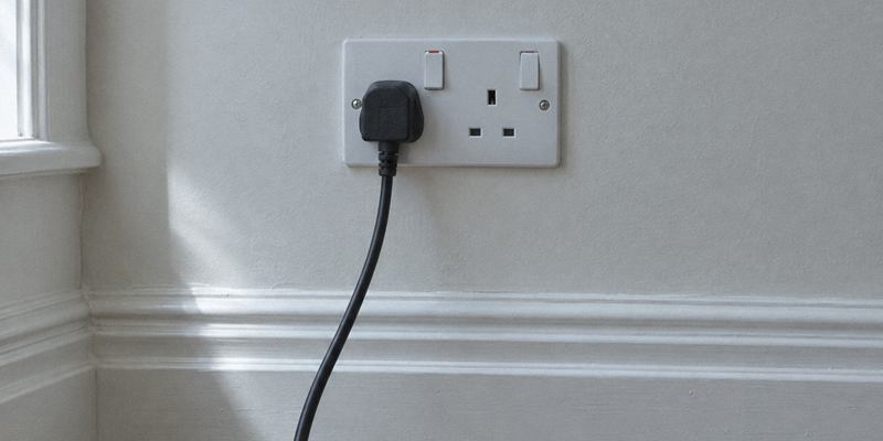 Test lead plugged into a UK double socket during an electrical inspection